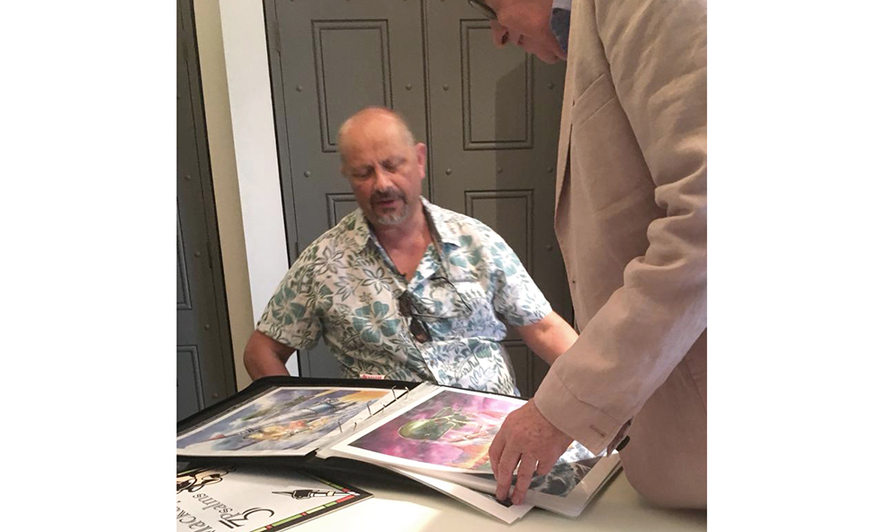 Andy Mackay looks through artwork by Lee Sullivan
